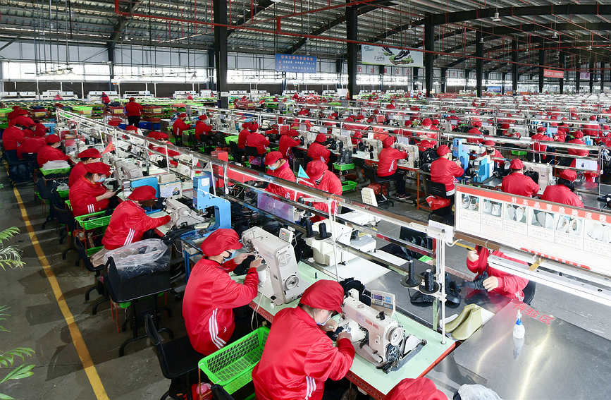河南睢县某鞋业生产车间，工人们紧张地忙碌着。黄业波摄