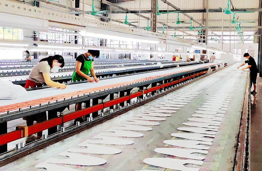 河南睢县某鞋业生产车间，工人们紧张地忙碌着。黄业波摄