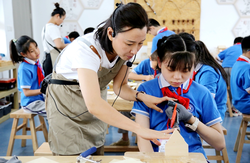 学校的木工坊里，孩子们在学习打磨。韩胜楠摄