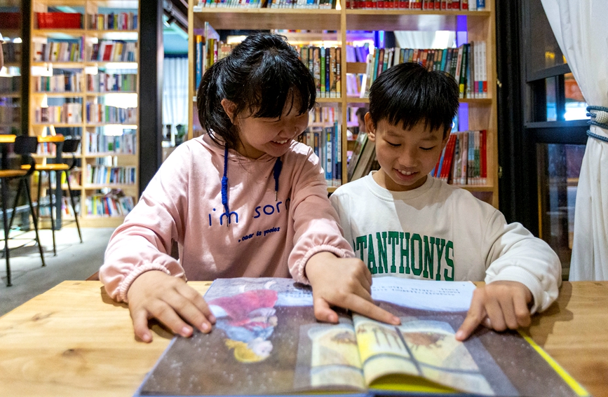 夜幕降临，河南省安阳市安阳县西裴小镇又“亮”了起来，姐弟俩在农家书屋内阅读交流。王建安摄