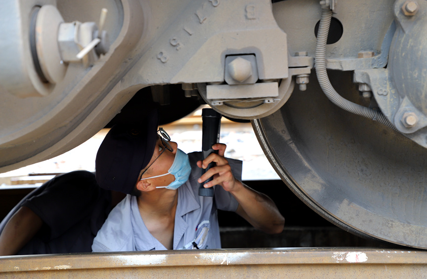 郑州车辆段检车员正在对车体转向架进行检查。刘雨摄