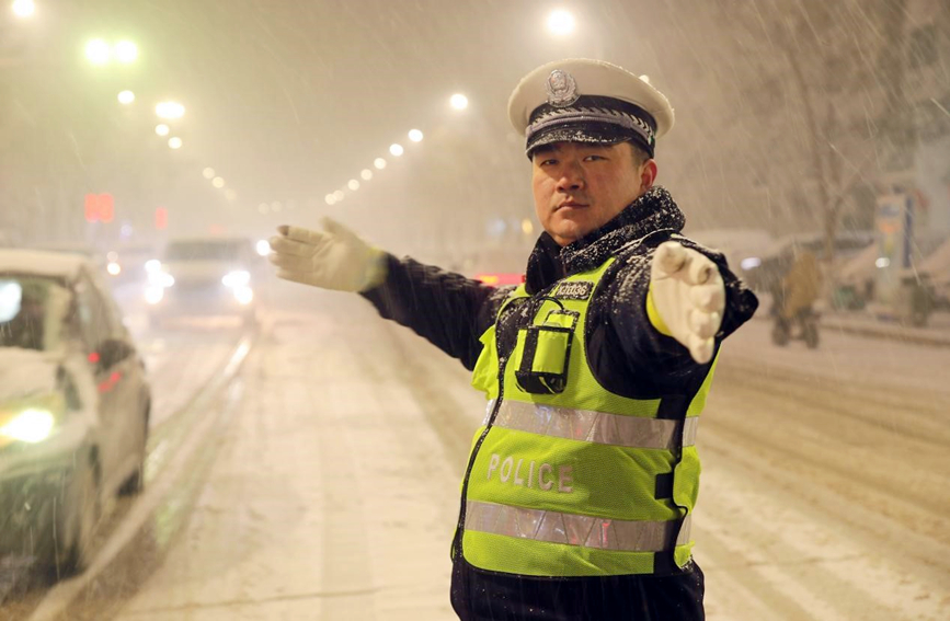 河南尉氏县交警在风雪中执勤。李新义摄