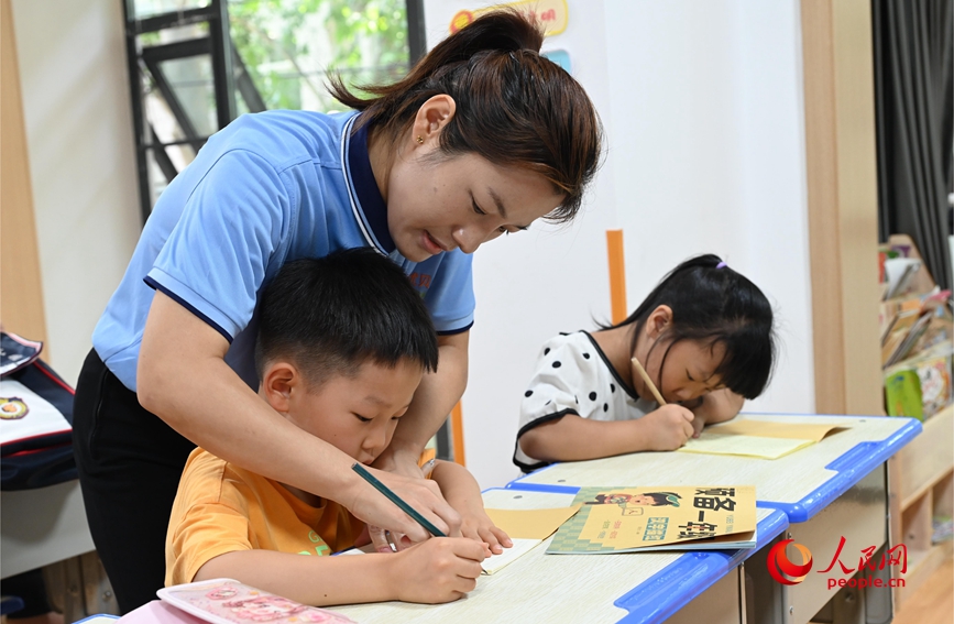 辅导孩子书法。人民网记者 王玉兴摄