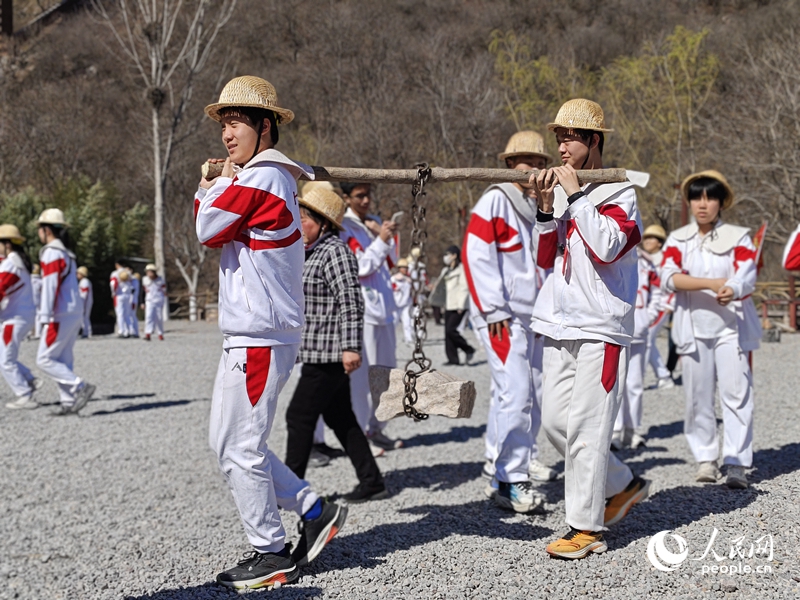 青年洞实训基地内，学生们分组合作，模拟修渠劳作，在实操中体悟“自力更生、艰苦创业、团结协作、无私奉献”的红旗渠精神。人民网记者 尚明桢摄