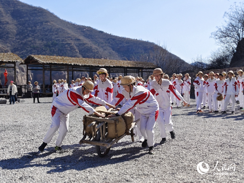 青年洞实训基地内，学生们分组合作，模拟修渠劳作，在实操中体悟“自力更生、艰苦创业、团结协作、无私奉献”的红旗渠精神。人民网记者 尚明桢摄