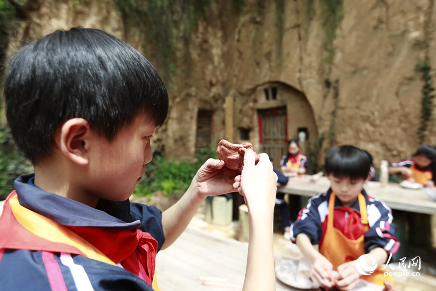 孩子们通过拍、搓、揉、捍、点等手法，感受泥块在手中的快乐。人民网记者 慎志远摄 