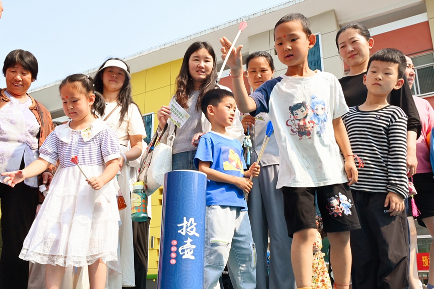 5月28日，河南省南阳市社旗县第三幼儿园举办“双节同庆 童心‘粽’在”亲自游园活动，孩子们在玩趣味投壶游戏。申鸿皓摄