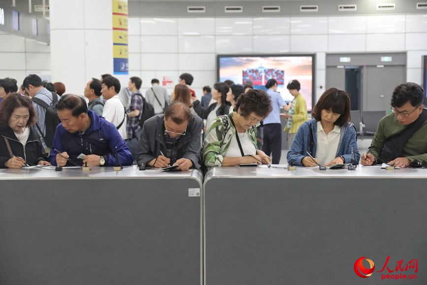 旅客在填写入境信息。人民网 霍亚平摄
