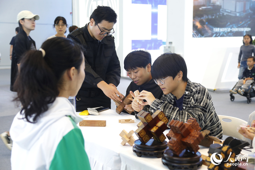 观众近距离了解鲁班锁制作技艺。人民网记者 慎志远摄