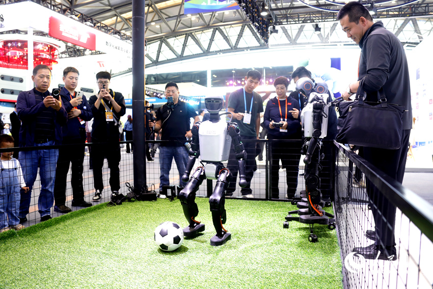 观众围观机器人踢足球。人民网记者 慎志远摄