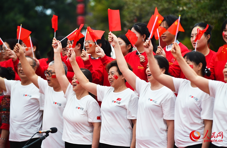 国庆中秋假期，游客在河南洛阳老城区历史文化街区洛邑古城齐唱歌曲祝福祖国。 人民网记者 尚明桢摄