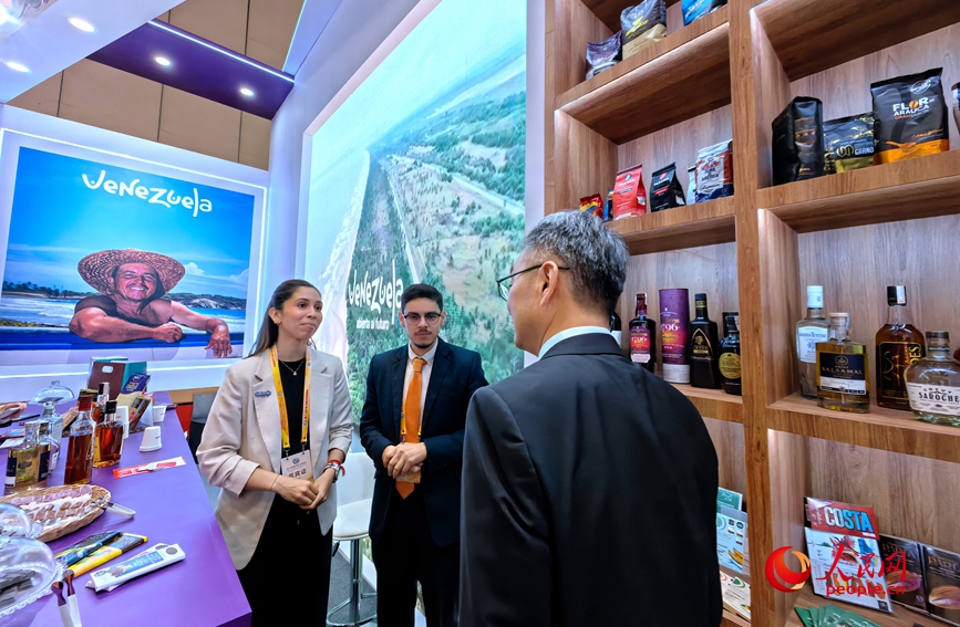 第十八届中国—拉美企业家高峰会展示区，双方代表驻足洽谈。人民网记者 宋芳鑫摄