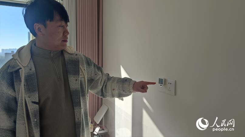 李先生介绍室内温度情况。人民网记者 杨晓娜摄