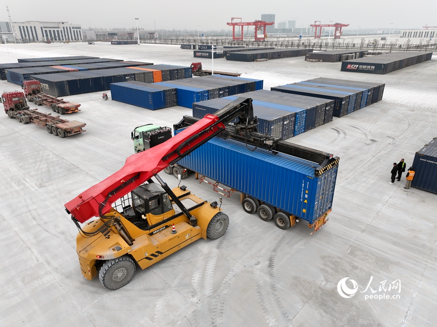 2月5日，在新郑市中欧班列集结中心东作业区，准备发往老挝的集装箱正在装车。人民网记者 辛静摄