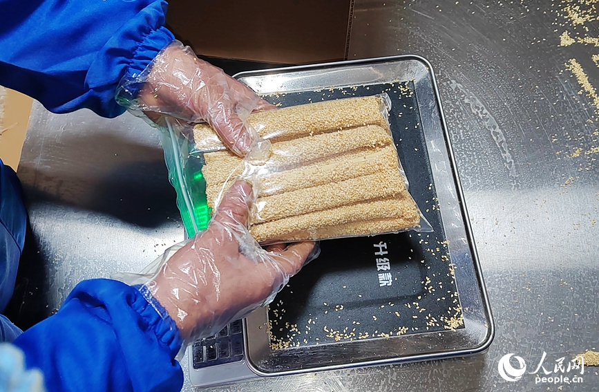 村民正在给制作好的麻糖称重。人民网记者 宋芳鑫摄