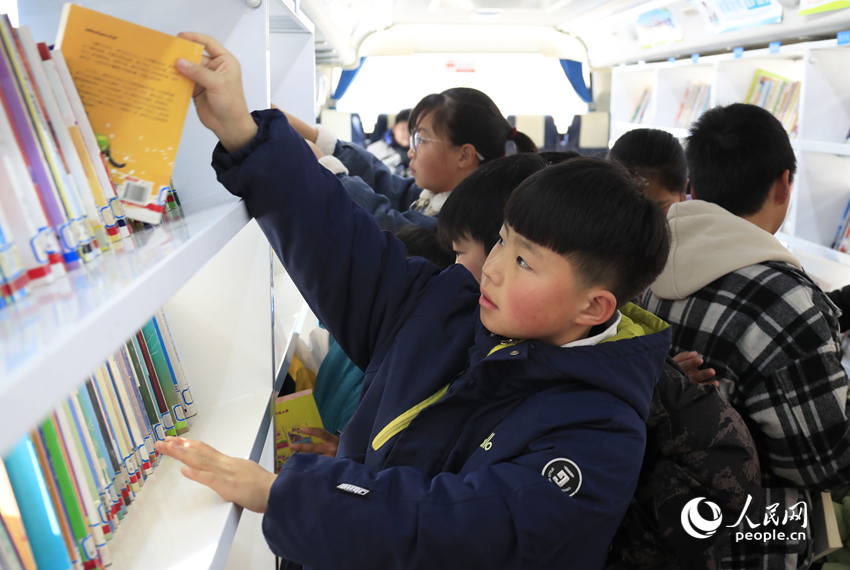 孩子们在图书车上挑选喜欢的书籍。人民网记者 慎志远摄