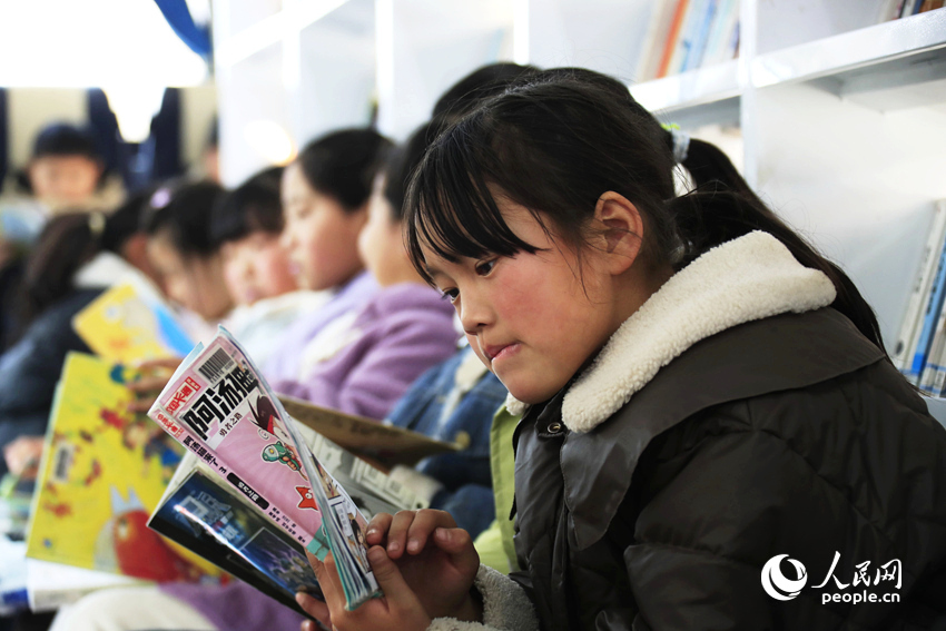 孩子们在图书车上阅读。人民网记者 慎志远摄