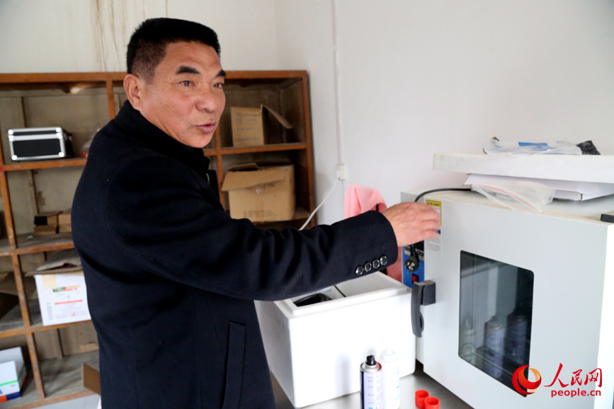 劳建军向大家介绍养殖医疗设备。人民网记者 于思远摄