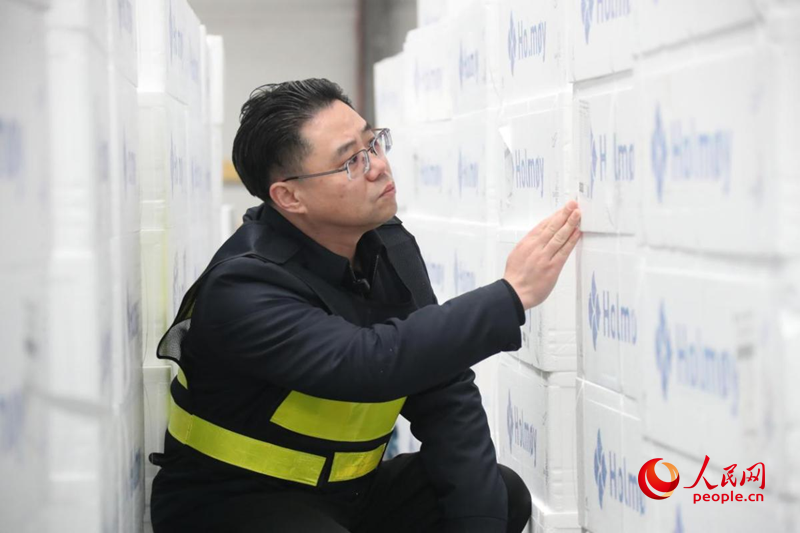       郭黎民在郑州机场北货站待放行理货区验货。人民网记者 霍亚平摄