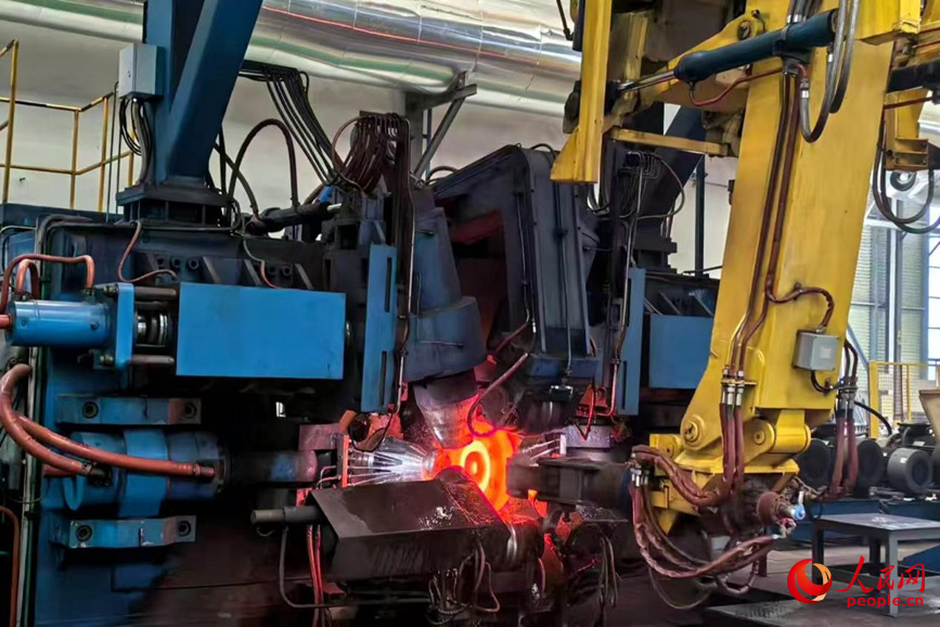 车轮被送进轧机。人民网 程明辉摄