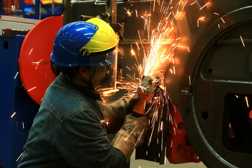 工人们正在用砂轮机打磨零部件上毛刺。王建栋摄