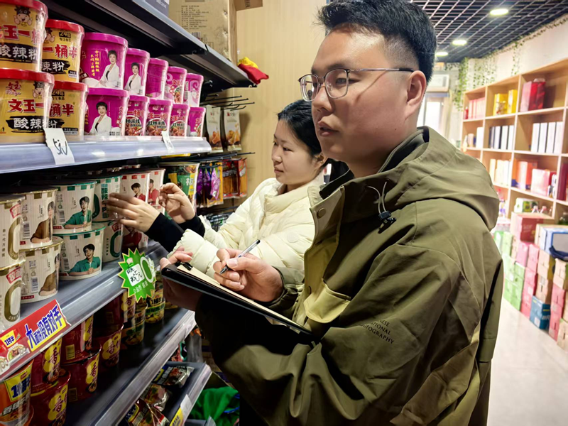 青年客户经理在帮助店铺开展经营分析。王辉摄