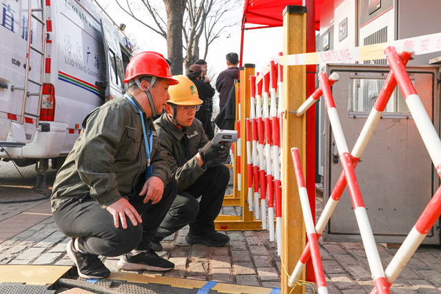4月1日,国网洛阳供电公司保电人员在第43届中国洛阳牡丹文化节开幕式现场监测供电设备运行状态。张果峰摄
