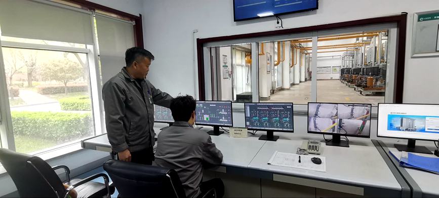 工作人员正结合监控数据交流分析设备运行情况。张百根摄