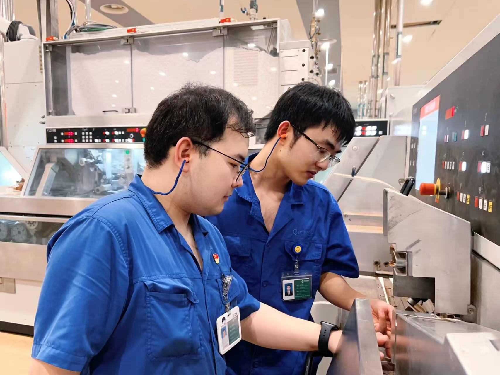 卷包车间青年职工讨论设备操作经验。 杨天语摄