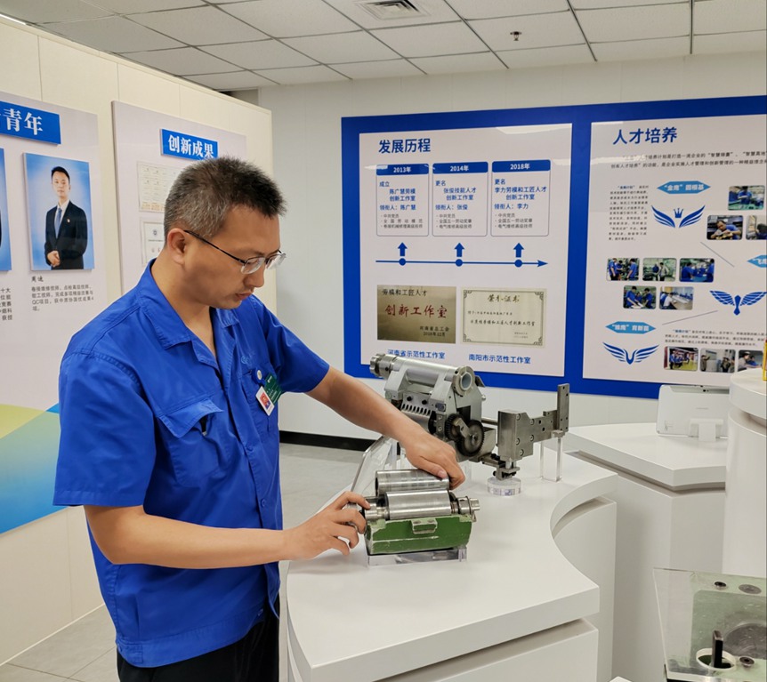 图为张书杭在工作室内电工实训平台进行电路模拟测试。