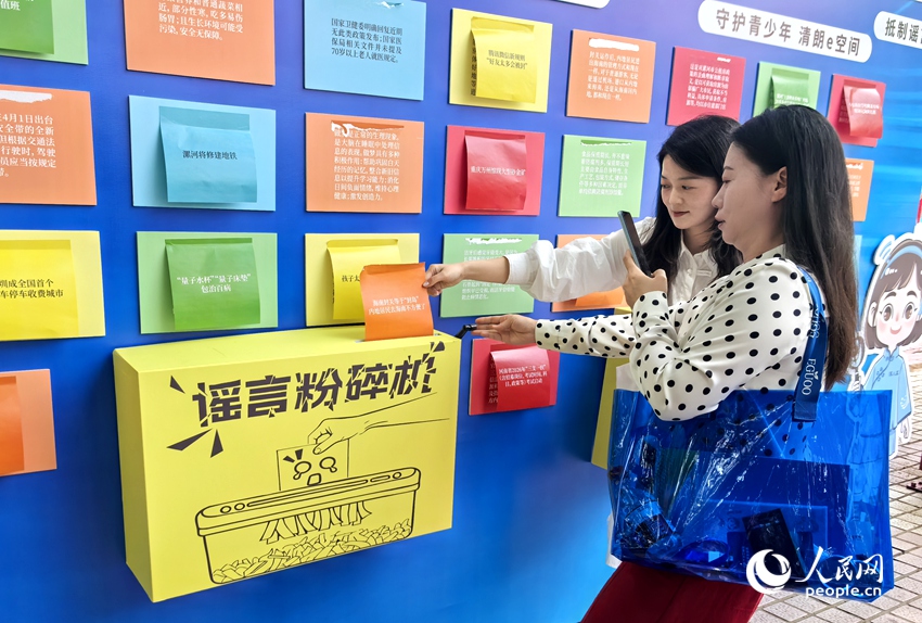 游客在“谣言粉碎机”处参与互动。人民网记者 王佩摄