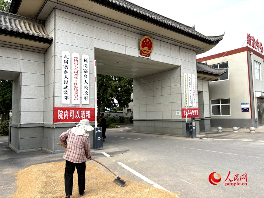 群众在瓦岗寨乡政府门口晒麦子。人民网记者 宋芳鑫摄