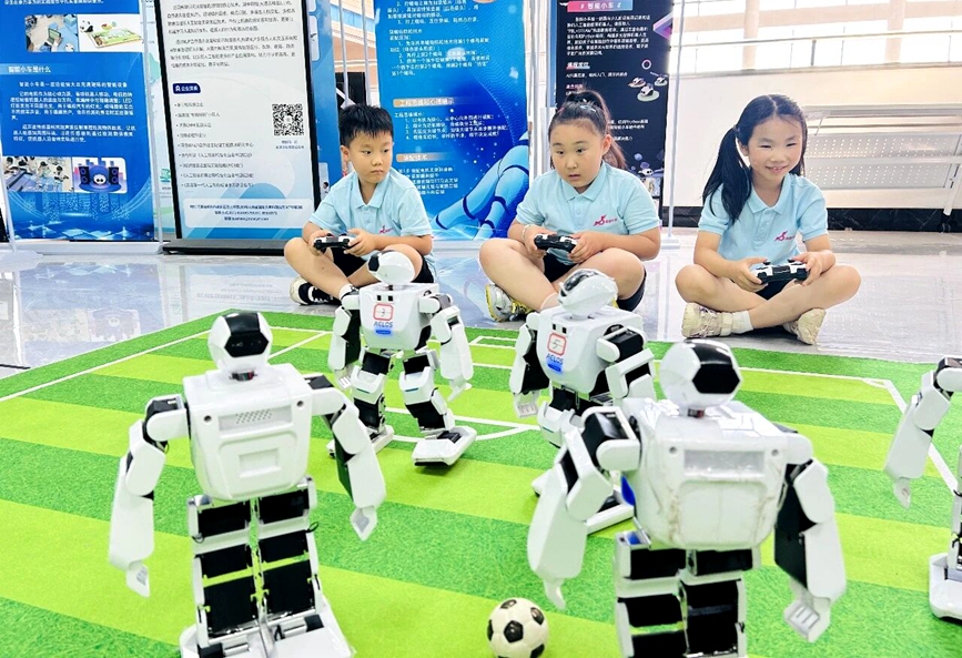 夏令营课堂内，宇通集团职工子女操作设备，沉浸式体验机器人操控乐趣。吴亚坤摄