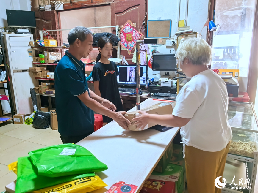 村民在村级代收点收快递。人民网记者 王佩摄