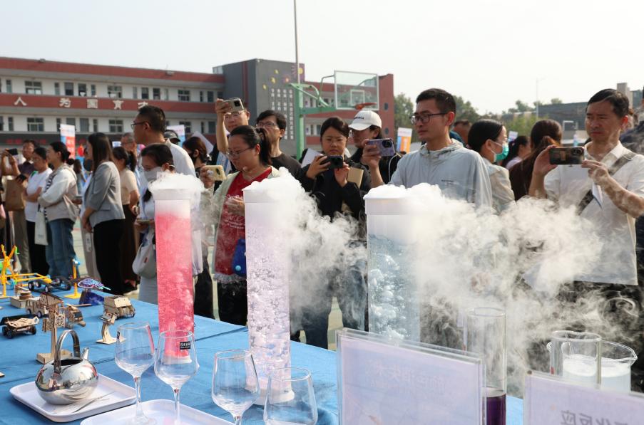 与会嘉宾在妙趣实验场·科学游乐园展区驻足体验科学奥秘并拍照。翟登云摄