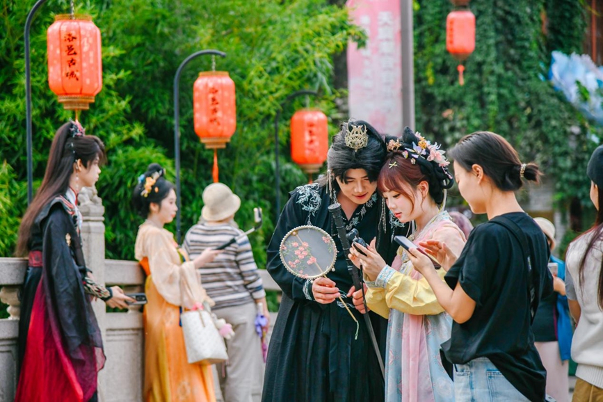 游客身着汉服在洛邑古城打卡拍照。王玺摄
