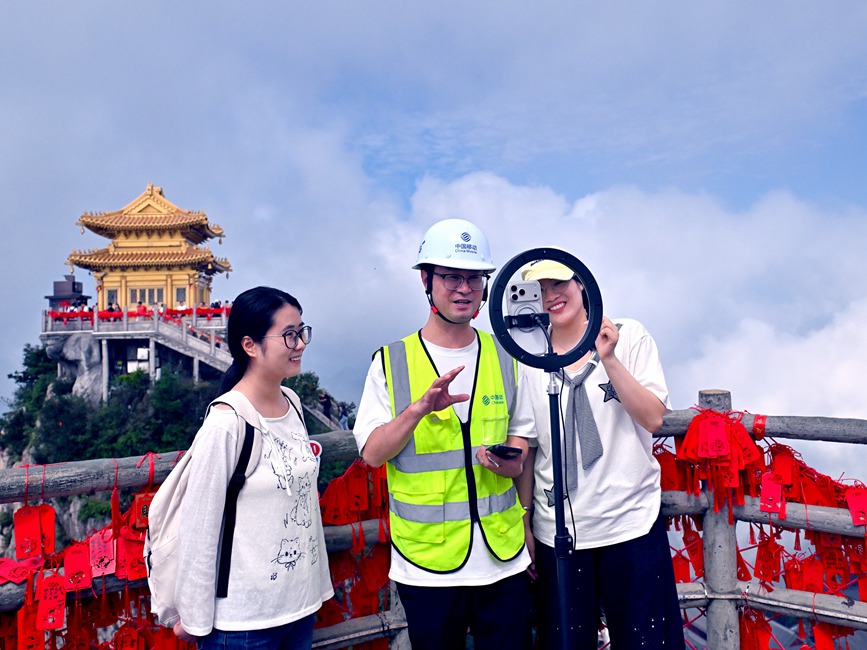 图为河南移动网络保障人员介绍山岳5G—A专网，现场展开高山云海高清直播。沈会阳摄